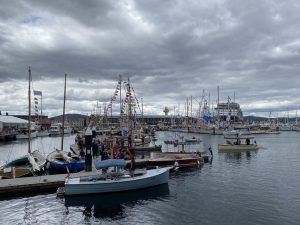 Wooden boats lined along the Hobart waterfront, adorned with colourful flags